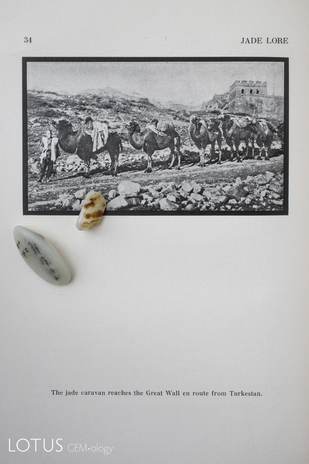 Two pieces of Hetian (Khotan) jade sit atop a photograph of a jade caravan from John Goette's Jade Lore.