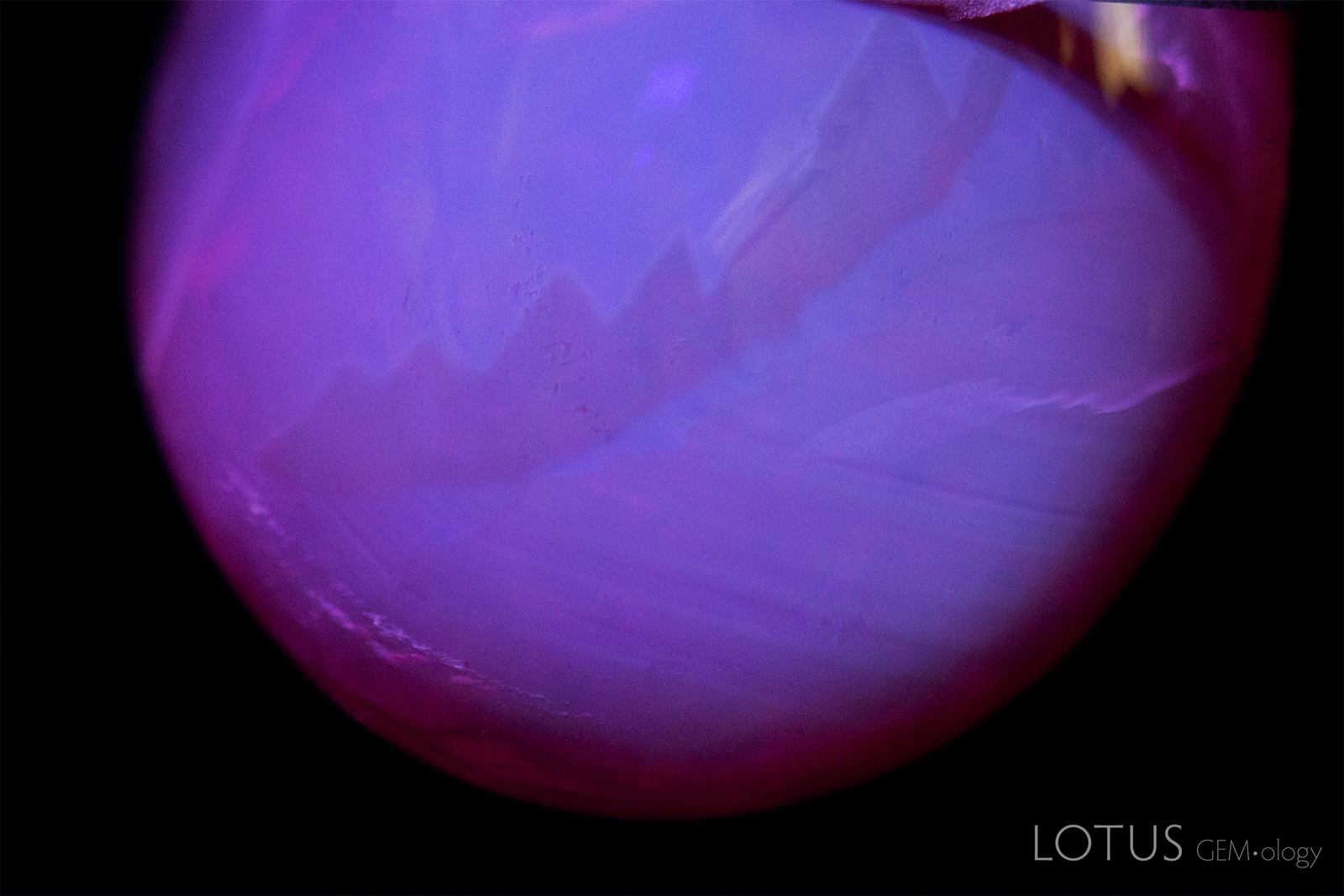 A complex angular zoning pattern is visible when the stone is magnified under short-wave UV illumination.