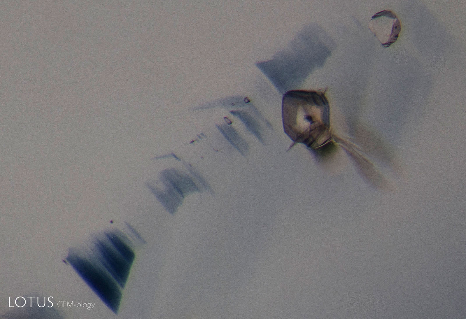 B: With heating to 1000°C, the larger crystal shows heat damage, with a glassy fissure forming around it. Note how the background color has lightened.
