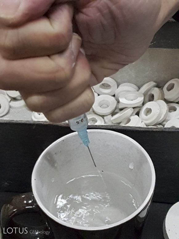 Typically a few drops of water are placed into the crucible with the graphite (left). After the crucible is full (right), it is sealed with a small ceramic ring and a plate of molybdimum (not shown).