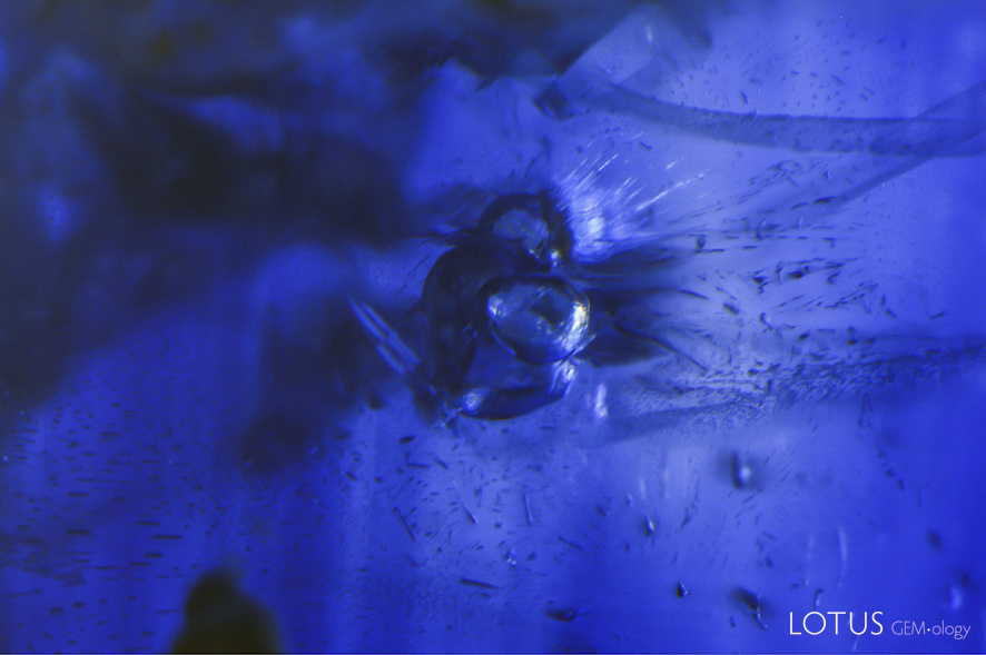 Pressure-heated sapphire before (left) and after (right) treatment. In this case, there was typical damage from high temperature heat treatment, and also a great improvement of color of the gem.
