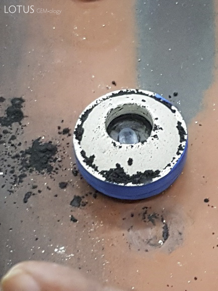 The sapphire to be treated is placed into a crucible (left). Generally only one stone per crucible is treated. The crucible is then packed tightly with graphite powder. The graphite not only produces a reducing atmosphere, but also ensures that the heat of the furnace is equally distributed.