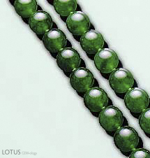 Figure B-2. Jadeite jade typically contains at least 90% jadeitic pyroxene in a rock that is typically more granular than nephrite. Note the vitreous surface luster of these translucent jadeite beads, which range from 9 to 10.5 mm in diameter. Photo courtesy of and © Christie's Hong Kong and Tino Hammid.