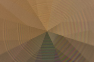 Polysynthetic twinning in a yellow sapphire creates a fanciful pattern due to the round shape of the gem.