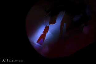 When iron-poor rubies from metamorphic deposits are heat treated, they often develop angular chalky zones when viewed in shortwave ultraviolet light. A great example of this is shown in this photograph, taken with Magilabs Deep Ultraviolet tool.