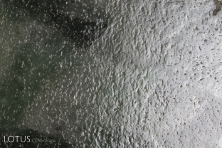 The various crystal grains that are packed into lower quality jade are not aligned in a single direction. This causes the “orange peel” surface that is shown here. It results from undercutting, as crystals aligned in the soft direction are more easily cut away than those aligned in the hard direction.