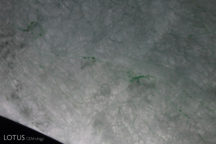 Green color concentrations can be observed in the fissures of this dyed (C-jade) fei cui bangle.