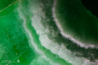 An unusual white banding pattern creates a radial structure in this sample of fei cui jade.