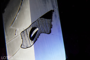 Glass filling in a surface-reaching cavity in a Mozambique ruby. Note the conchoidal fracture on the glass filling.